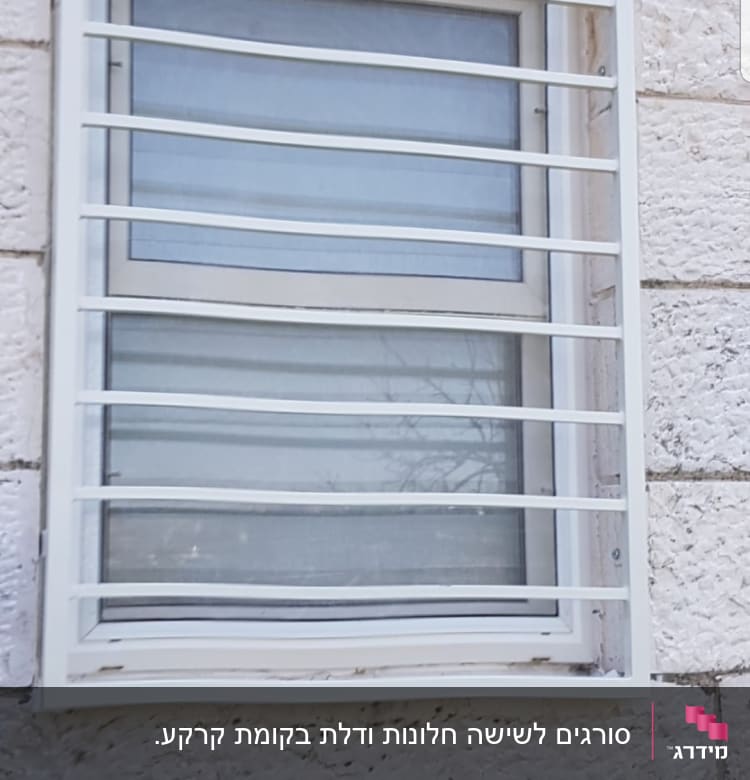 חלון עם סורגים לבנים על קיר אבן